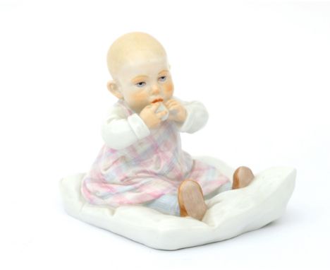 Konrad Hentschel (1872-1907) A porcelain figure of a child sitting on a cushion, produced by Meissen, Germany, post-war produ