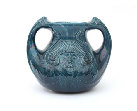 De Distel, Amsterdam A blue glazed ceramic two-handled vase, decorated with female head in relief, signed with painted mark u