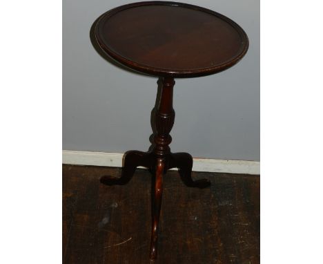 A 20th century mahogany circular wine table, raised on tripod legs.