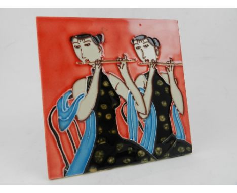 A Continental square porcelain tile, painted and having tube lined decoration with two ladies playing flutes. D.15cm