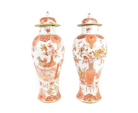 A Pair of Chinese Porcelain Baluster Vases and Covers, Yongzheng/Qianlong, painted in iron red and gilt with precious objects