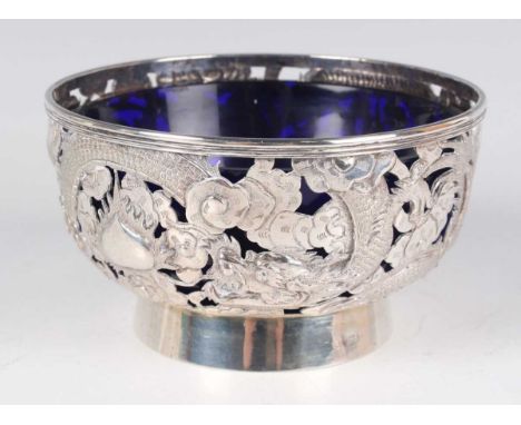 A late 19th/early 20th century Chinese silver bowl, the circular body pierced and engraved with dragons amongst clouds, raise