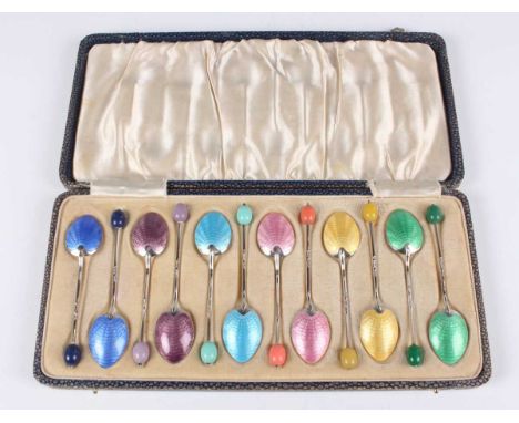 A set of twelve George V silver and varicoloured enamel coffee spoons, each with varicoloured faux bean terminals, Birmingham