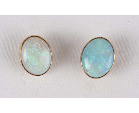 A pair of gold and opal single stone ear studs, each collet set with an oval opal, indistinct marks to the gold posts, the bu