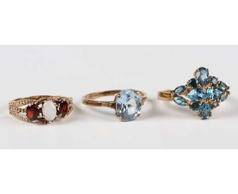A 9ct gold, opal and garnet three stone ring, London 1976, ring size approx P1/2, a 9ct gold and pale blue gem set cluster ri