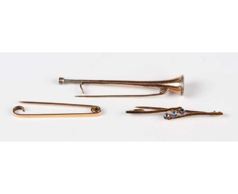 Three gold brooches, comprising a sapphire set three stone bar brooch in a twistover design, detailed ‘15ct’, weight 2.6g, wi