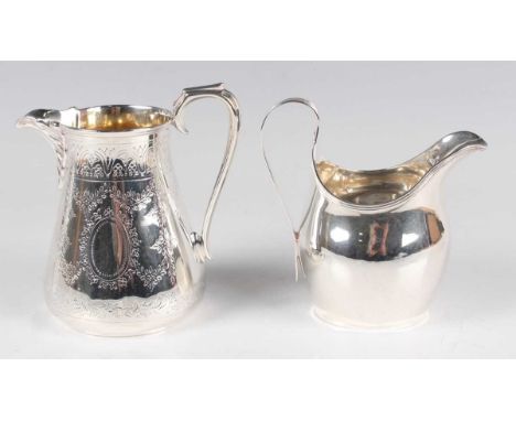 A Victorian silver tapering cylindrical milk jug, engraved with floral garlands, flanked by a scallop shell spout and scroll 