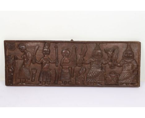 Rectangular Benin carved wooden board, 81cm x 27cm, carved with 5 standing figures including 2 with large knives, one holding