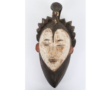 Carved Tribal wooden face mask, 38cm, with carved hair surmounted by a perched bird, face with predominantly white pigment, e
