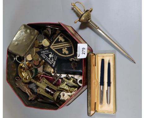 Tin box of oddments to include bottle openers, miniature sword, brass cork screw, vintage keys, clay pipe, lighters, etc.(B.P