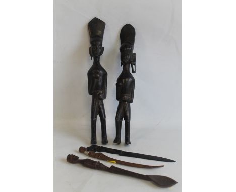 TWO AFRICAN CARVED HARDWOOD FIGURES, a carved wooden spoon with African soldier finial and two other minor carved items  (5)