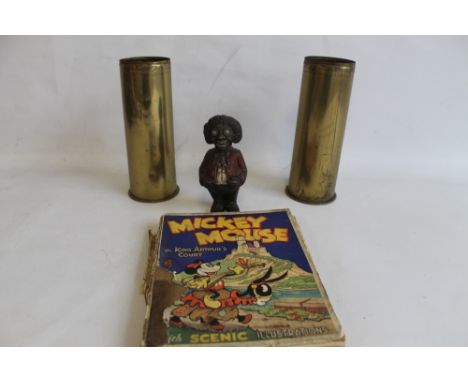 A GROUP OF COLLECTABLES consisting of two German brass shells dated 1910, a cast Golly money box and a Mickey Mouse book