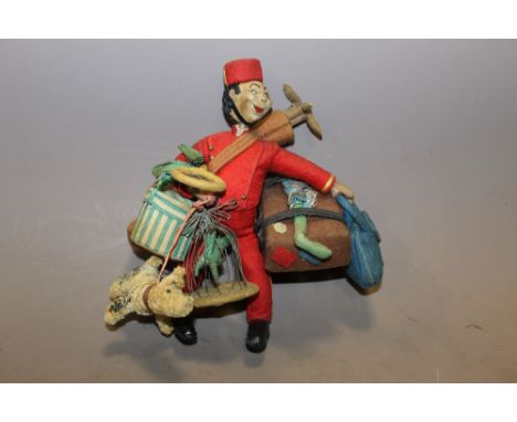 A VINTAGE BELL HOP DOLL CARRYING LUGGAGE