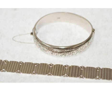 SILVER BROAD HINGED OPENING HOLLOW BANGLE, the foliate scroll engraved, Birmingham 1961 and  SILVER COLOURED METAL BRACELET, 