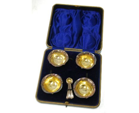 SET OF FOUR EDWARDIAN SILVER CIRCULAR PEDESTAL SALT RECEIVERS, with crimped petal form borders, gilt interiors, on cushion kn