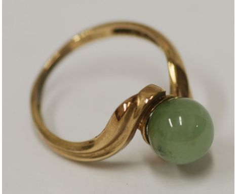 9ct GOLD SCROLLED CROSS-OVER RING, set with a spherical pale green jade stone, 3gms 