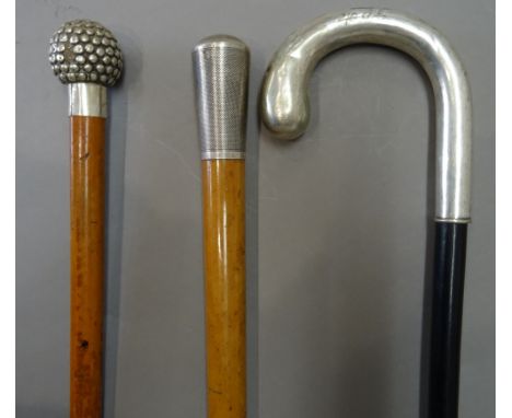 A silver topped malacca walking cane, engine turned and hallmarked London 1919 (88.5cm), a white metal topped malacca cane of