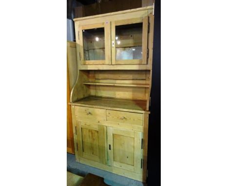 A 20th century Swiss pine dresser with two drawers over cupboard base and a two glass door fronted cabinet top, 112cm wide x 