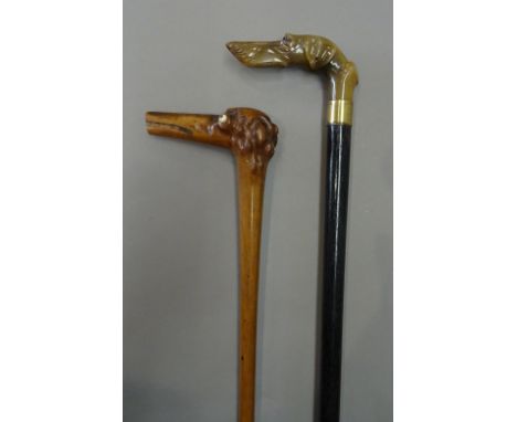 A Victorian horn and ebonised walking cane, the handle carved as a dog's head (90cm) and a similar dog's head walking stick o