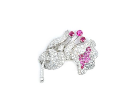 A ruby and diamond clip brooch, in a floral spray design, circa 1940, mounted with three principal circular cut rubies, furth