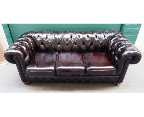 A 20th century brown leather button upholstered Chesterfield sofa, with rollover arms, 195cm wide x 95cm deep x 75cm high.