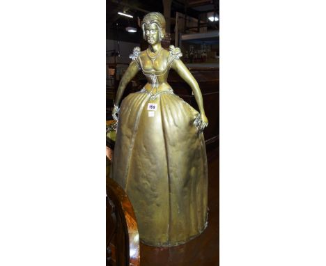 An early 20th century brass figural fireguard formed as a woman in Victorian dress, 45cm wide  x 80cm high.