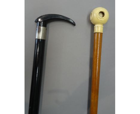 A Victorian ivory mounted 'Puzzle ball' walking cane (85.5cm) and an unusual ebonised gadget walking stick with torch light t