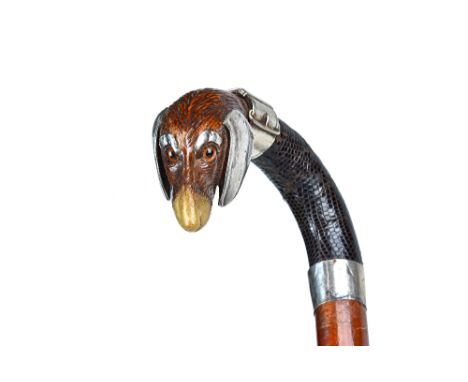 A Black Forest walking stick, circa 1900, with carved dog's head pommel, horn nose/mouth and white metal mounts, with a snake