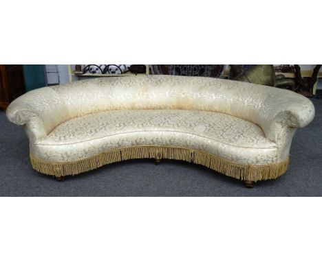 A 19th century kidney shaped Chesterfield style sofa with rollover back on turned gilt supports, 245cm wide x 65cm high.