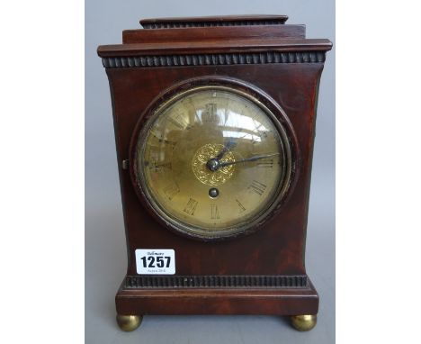 A French mahogany cased mantel clock, late 19th century, with stepped rectangular surmount and brass dial, on four spherical 