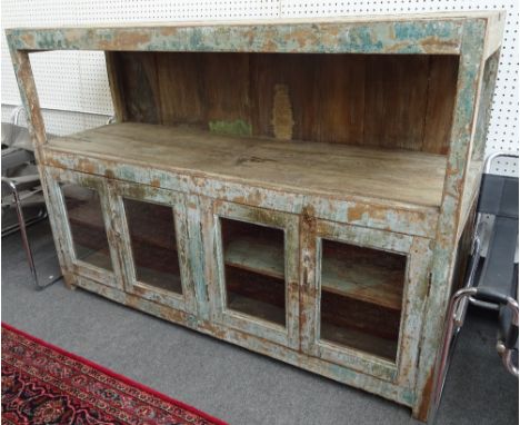 A distressed green painted hardwood side cabinet with two shelf tiers over four glazed doors on block feet, 170cm wide x 118c