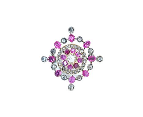 A diamond and ruby brooch, claw set with the principal cushion shaped diamond at the centre, in a surround of eight variously