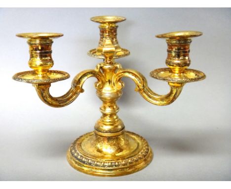 A French silver gilt three light table candelabrum, the three scrolled arms supporting individual candle holders of equal hei