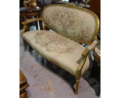 A Louis XVI style gilt framed open arm sofa on tapering fluted supports, 140cm wide x 95cm high.