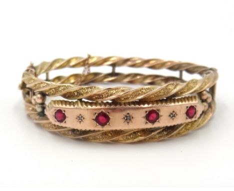 A 9ct gold, diamond and red gem set oval hinged bangle, the front mounted with four circular cut synthetic red gems and with 