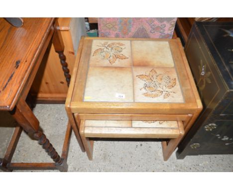 A nest of three teak and tile topped occasional tables 