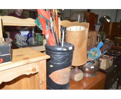 A pottery stick stand containing various walking sticks; shooting stick; umbrella etc