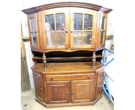 An oak display cabinet, the curved glazed top with four doors above two shelf base with cupboard drawers and single door, 193