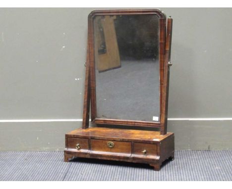 A George II style walnut dressing table mirror, the rounded rectangular bevelled plate within a cushion moulded frame on a pl