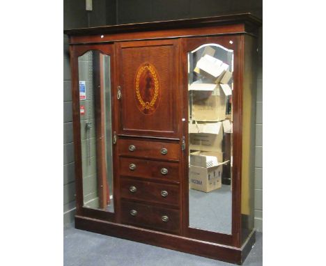 An Edwardian mahogany combination wardrobe, with central marquetry panel above four drawers, flanked by a pair of mirrored do