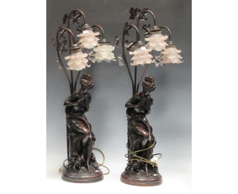 A pair of modern spelter three light lamps depicting classical maiden holding two birds, with floral glazed lamp shades