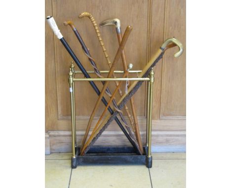 A Victorian brass stick stand and various walking sticks/canes