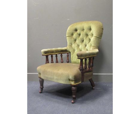 Circa 1860 a walnut green button back armchair, the curved armrests on turned supports and legs with ceramic castors