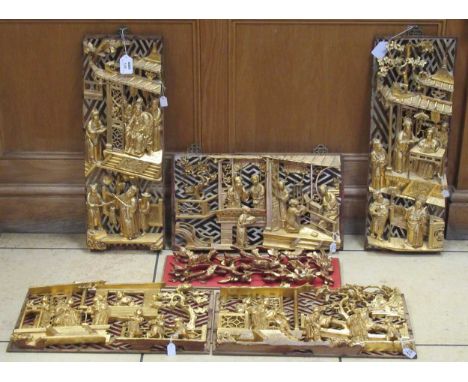A collection of oriental carved wood and gilt wall panels with traditional designs of figures within room settings, and anoth