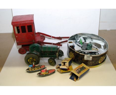 A small group of old toys including a crane, tractor and tin of die cast planes