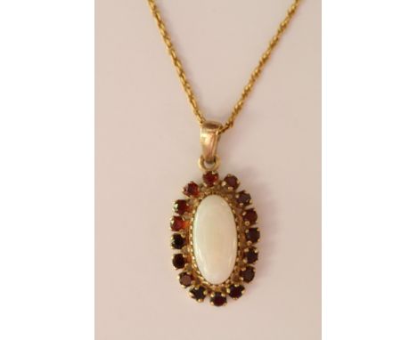 A 9ct gold pendant on chain set with a central opal with garnet surround