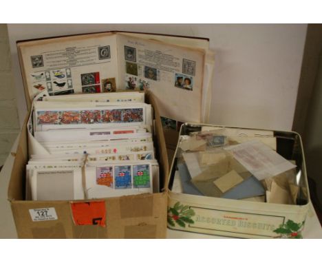 A box containing First Day Covers with a tin of stamps