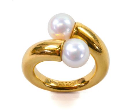 Cartier - An 18ct gold cultured pearl set ring. Crossover design with twin pearl terminals, French hallmarks, signed, inscrib