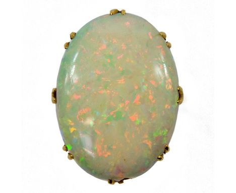 The large white opal showing multiple colours including red and measures 20mm x 15mm, stamped 18ct, size I, 4.7g.There is an 