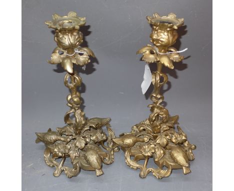 A pair of gilt metal candlestick holders with floral decoration